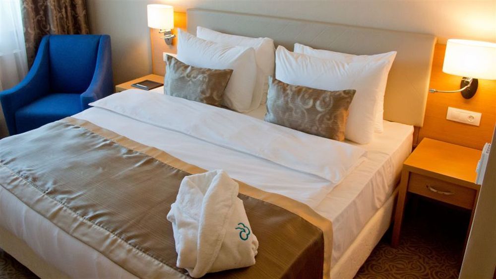 Dedeman Oskemen Tavros Hotel Ust-Kamenogorsk Exterior photo A bed with a duvet cover